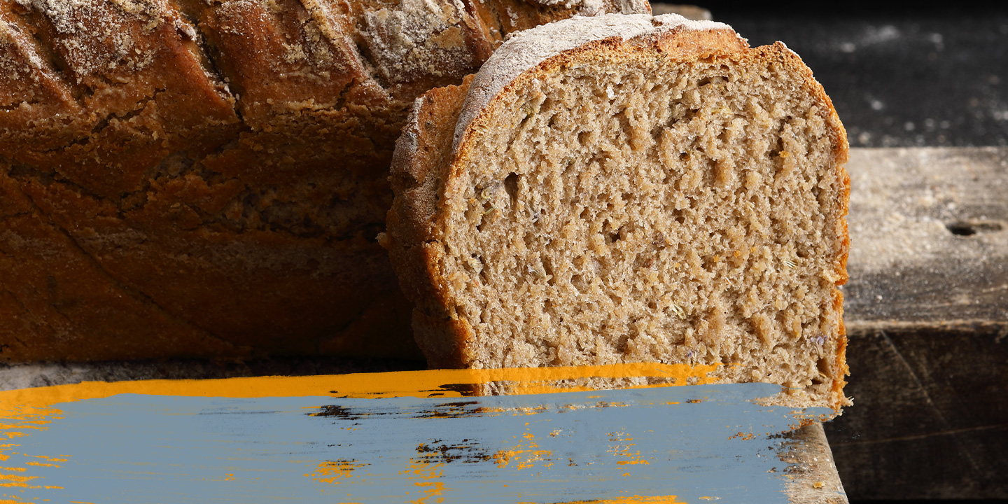 Gros plan sur du pain tranché sur une planche de bois, montrant la texture