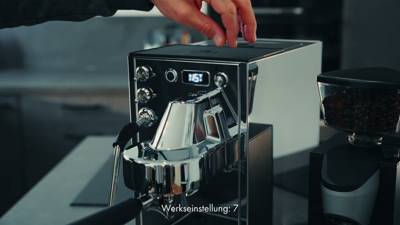 Eine Person bedient eine Kaffeemaschine mit Mühle.