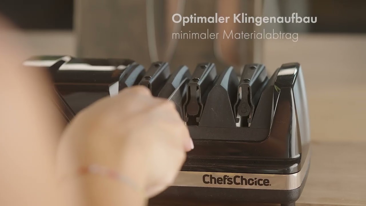 Ein Messer wird von einer Hand in einen scharfen Küchenhelfer eingeführt.