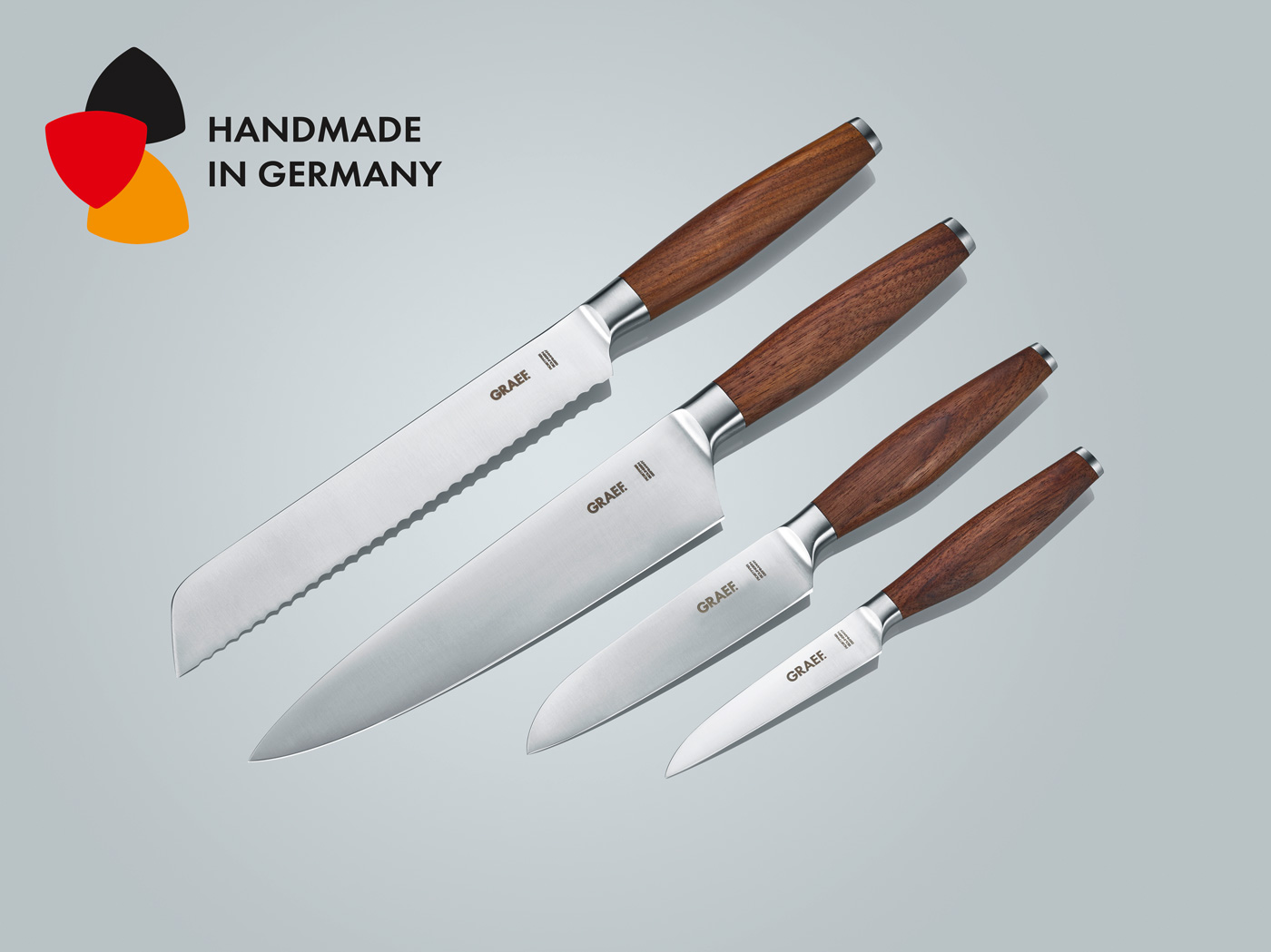 Messer-Set mit Holzgriffen, 'Handmade in Germany', auf grauem Hintergrund.