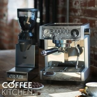 Macchina da caffè e macinacaffè su tavolo in legno con chicchi e tazza di caffè