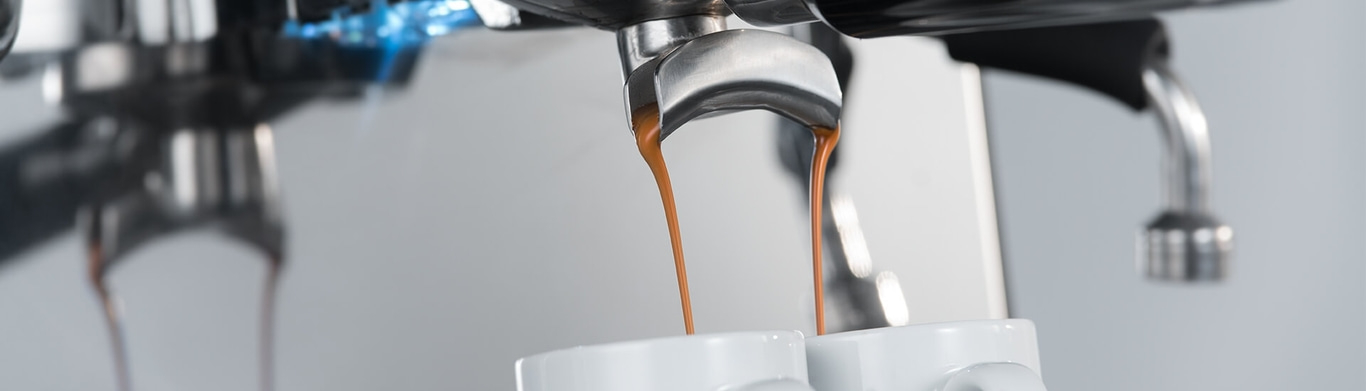 Espresso machine pouring coffee into cups, close-up shot, detailed view