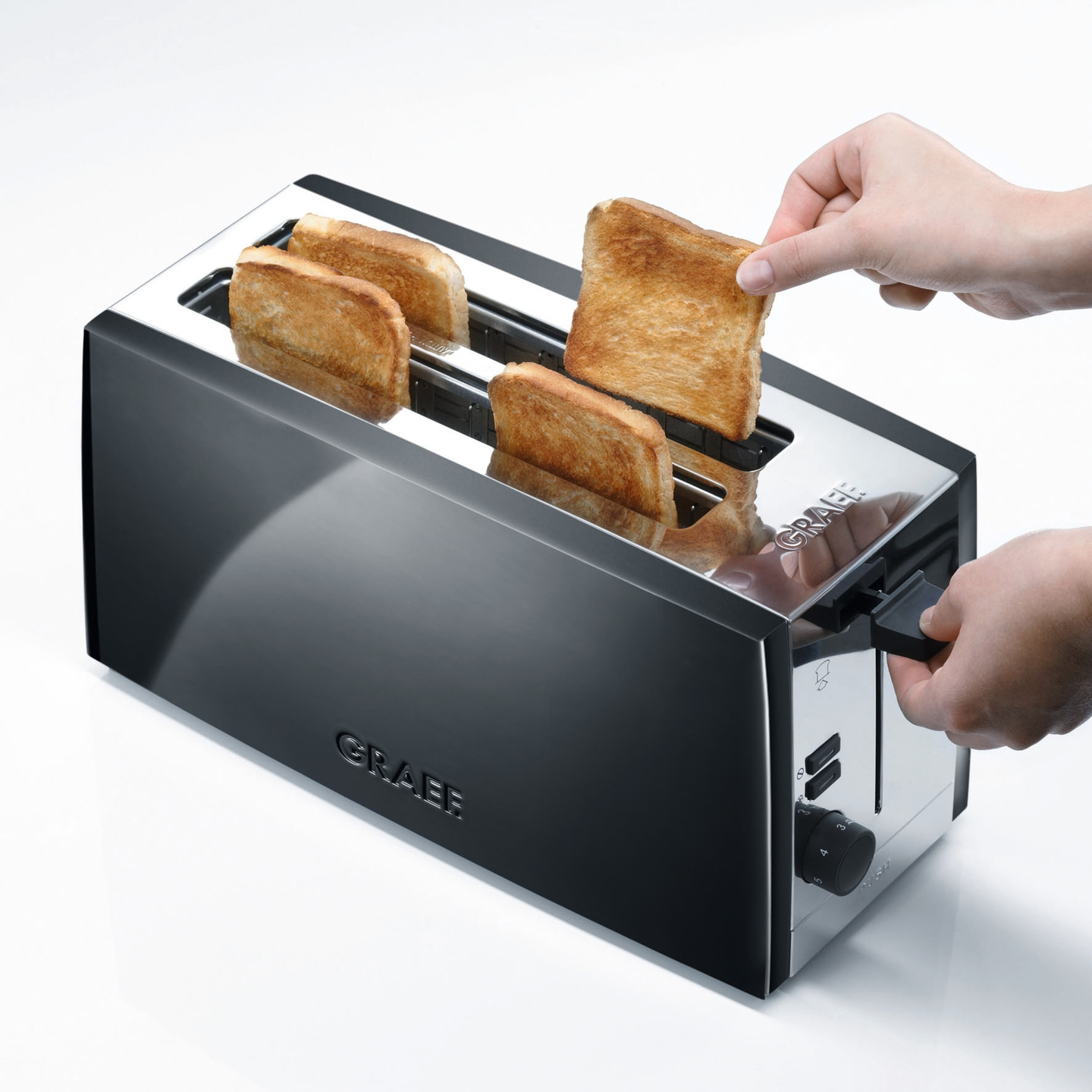 Ein Toaster mit Toastbrot, das aus dem Toaster genommen wird, Nahaufnahme.