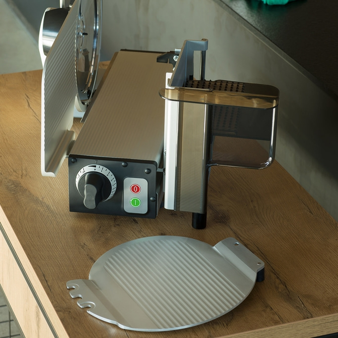 Trancheuse à viande sur table en bois avec accessoires et boutons