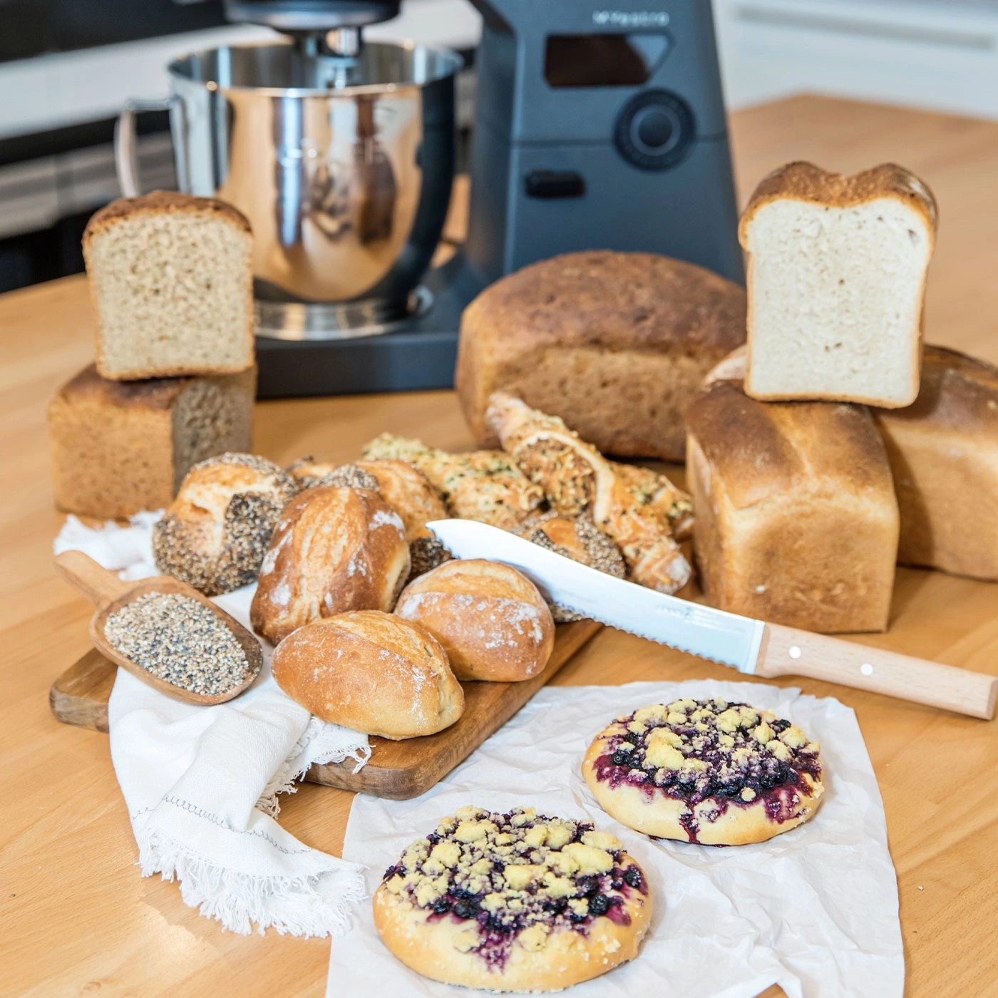 Brot, Gebäck und Küchenmaschine auf einem Holztisch