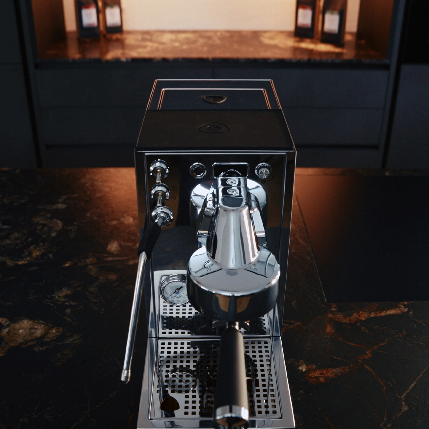 Eine glänzende Espressomaschine auf einer dunklen Marmorplatte in einer modernen Küche.