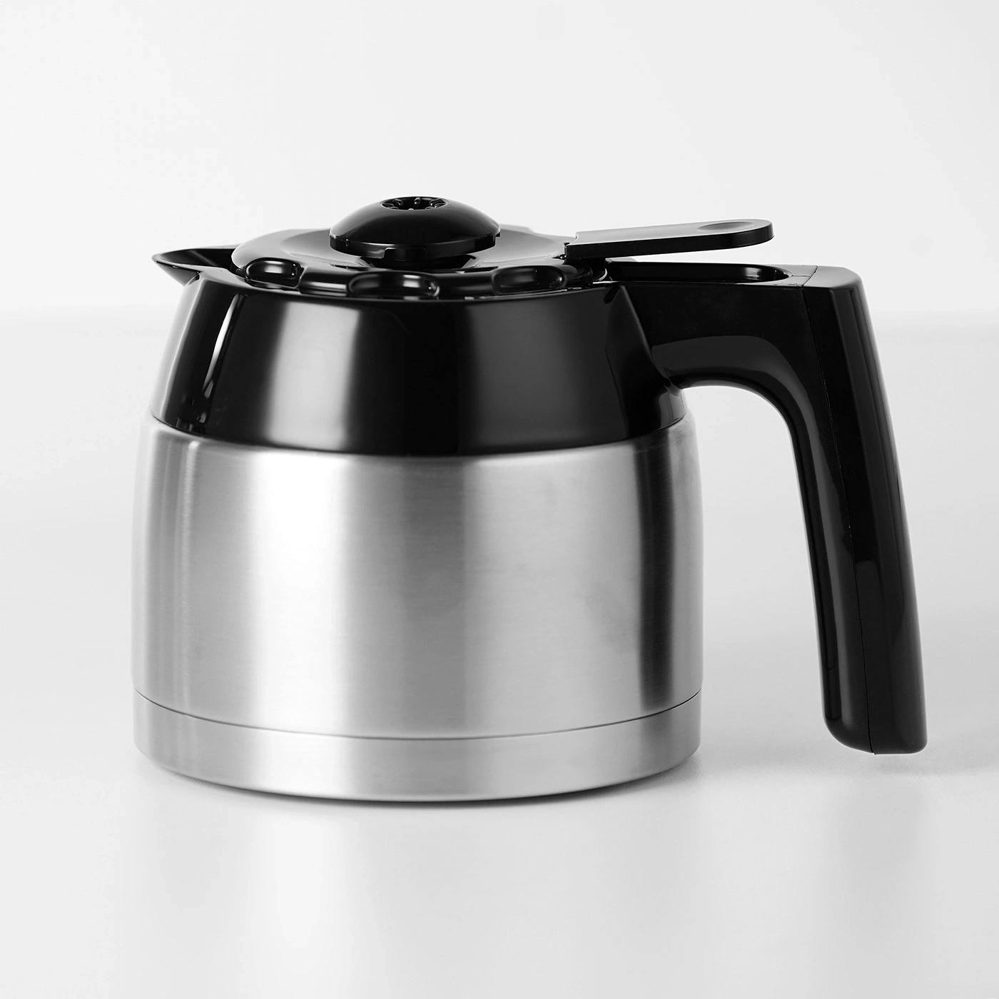 Kaffeekanne aus Edelstahl mit schwarzem Deckel und Griff auf weißem Hintergrund
