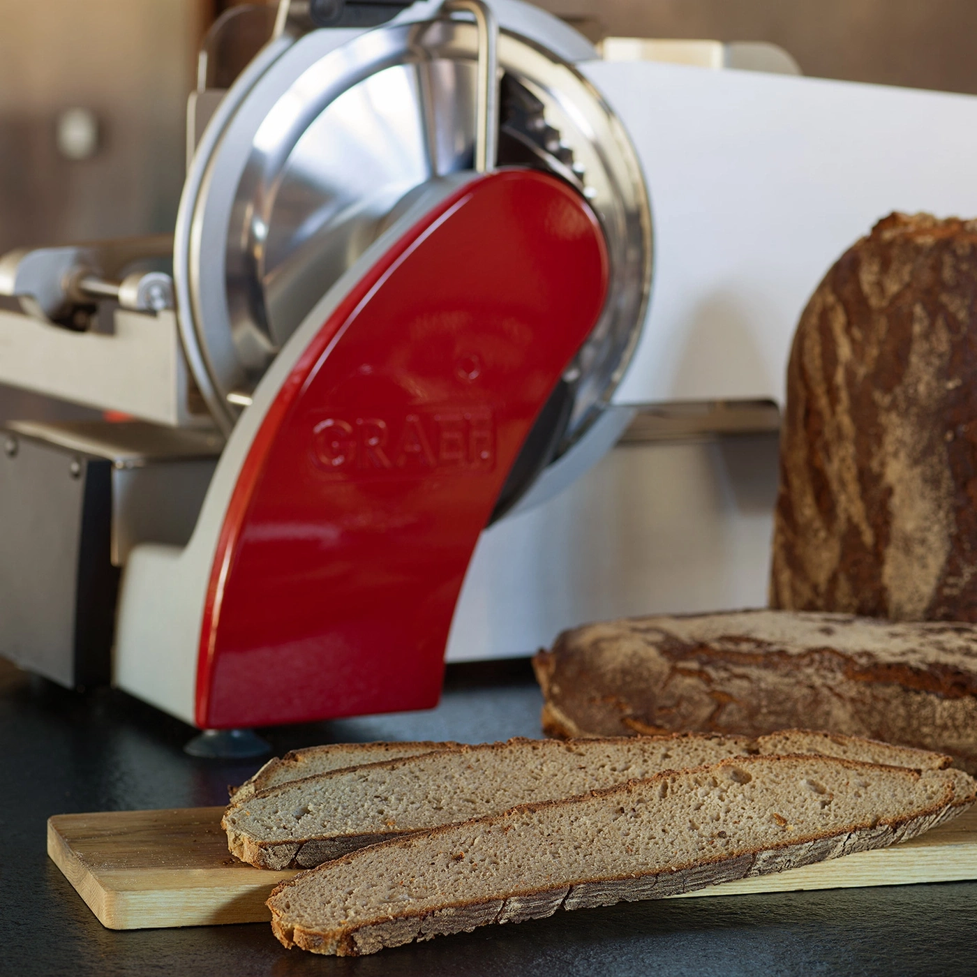 Brot in Scheiben geschnitten, Brotschneidemaschine, Holzbrett, Nahaufnahme