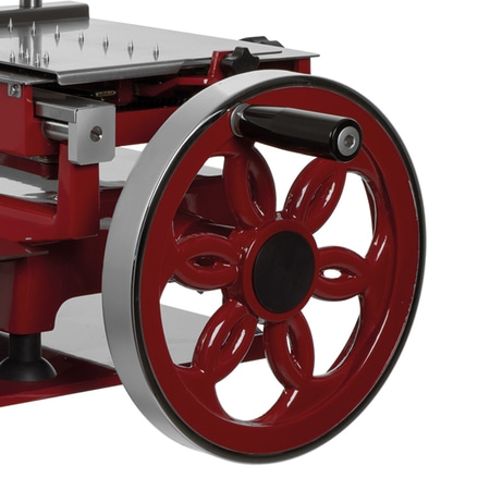 Nahaufnahme einer roten Aufschnittmaschine mit großem Rad und Griff