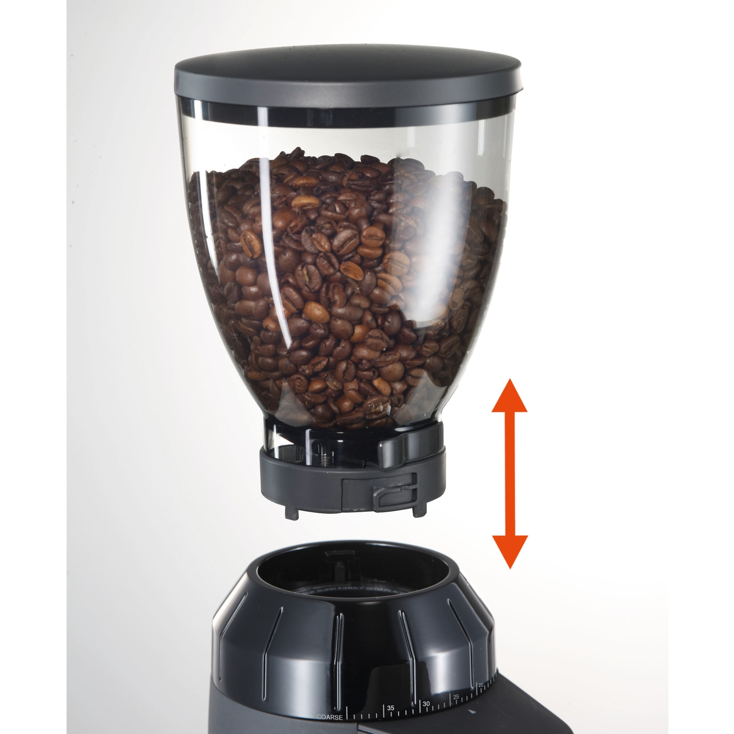 Moulin à café avec des grains, la flèche indique la direction du réglage.