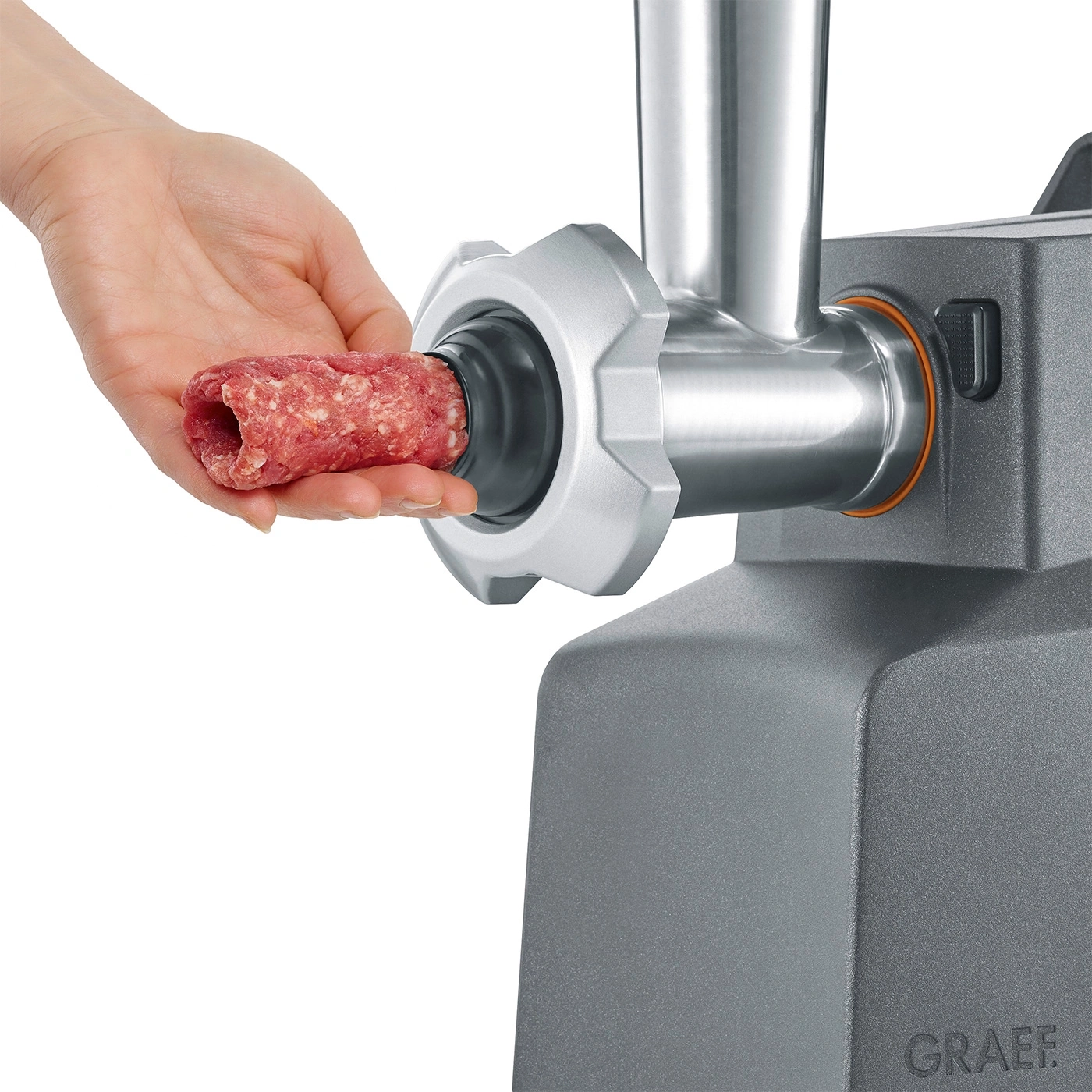 Fleischwolf mit Fleisch. Hand hält Fleisch. Graef-Logo. Nahaufnahme. Fleisch wird verarbeitet.