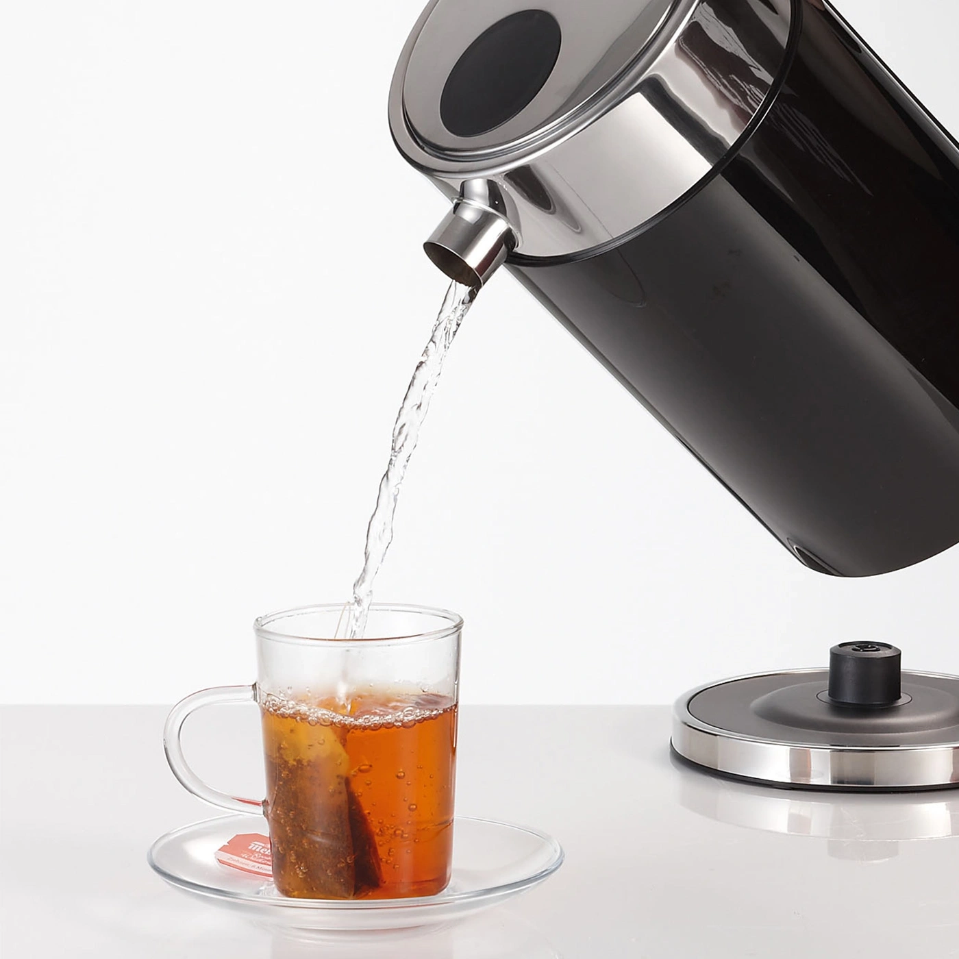 Wasser wird in eine Tasse mit Teebeutel gegossen.