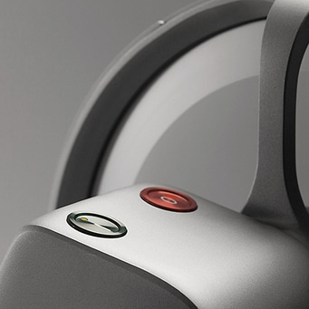 Close-up of two buttons on a silver device with a gray background and a circular design.