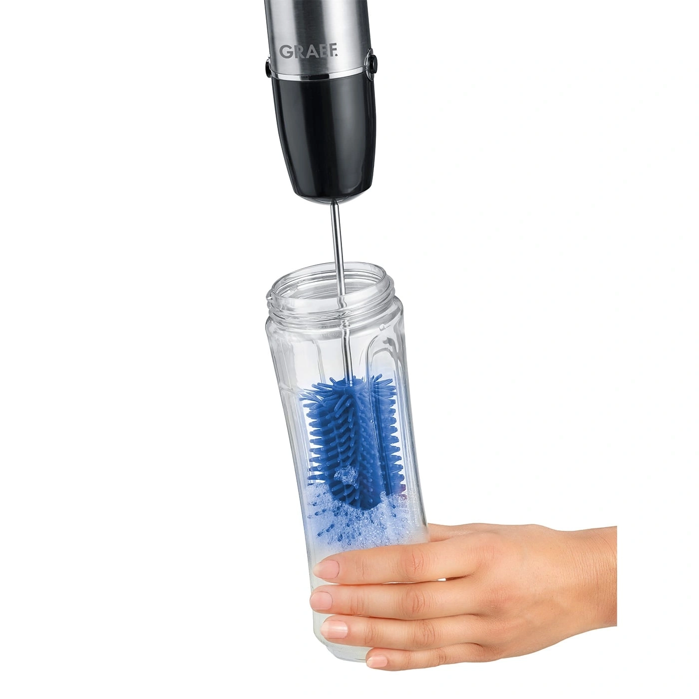 Eine Hand hält ein Glas, in dem eine blaue Bürste gereinigt wird.