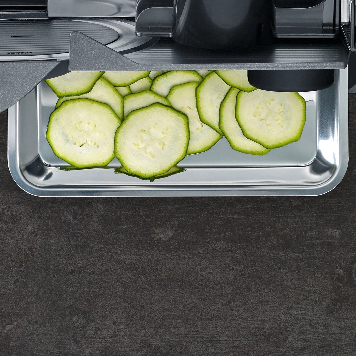 Geraffte Zucchinischeiben in einer Metallschale, bereit für die Zubereitung.