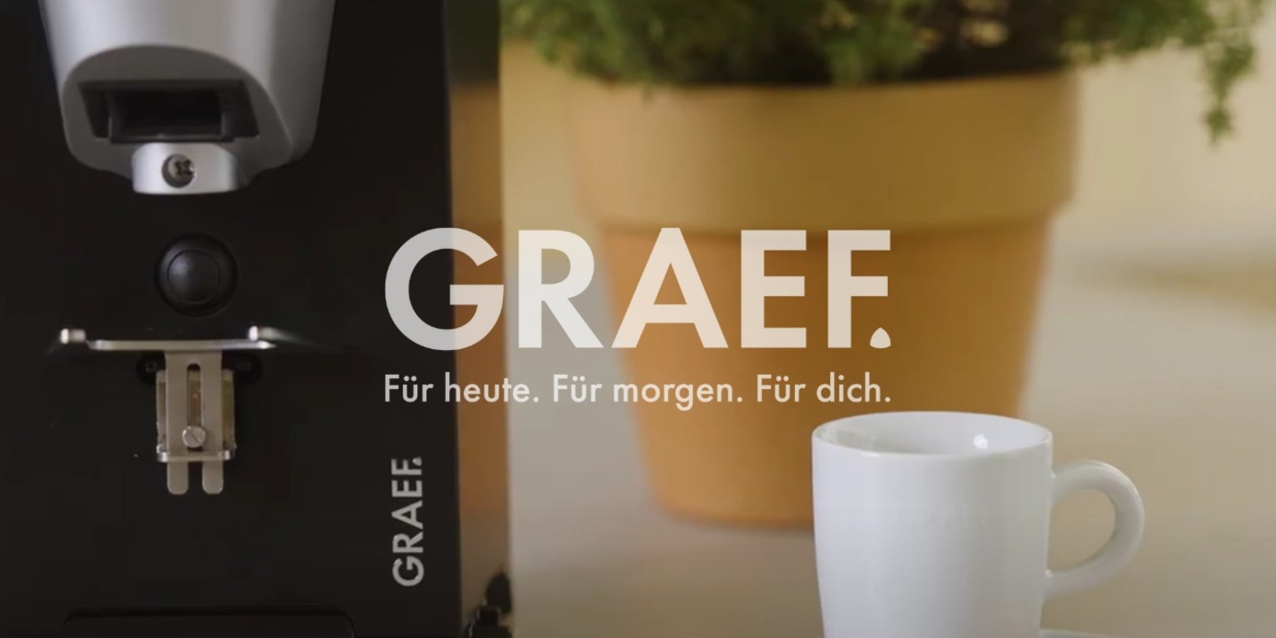 Machine à café avec tasse et pot avec plante, logo GRAEF