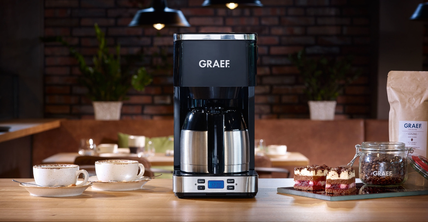 Coffee machine with accessories on a wooden table in a cafe setting