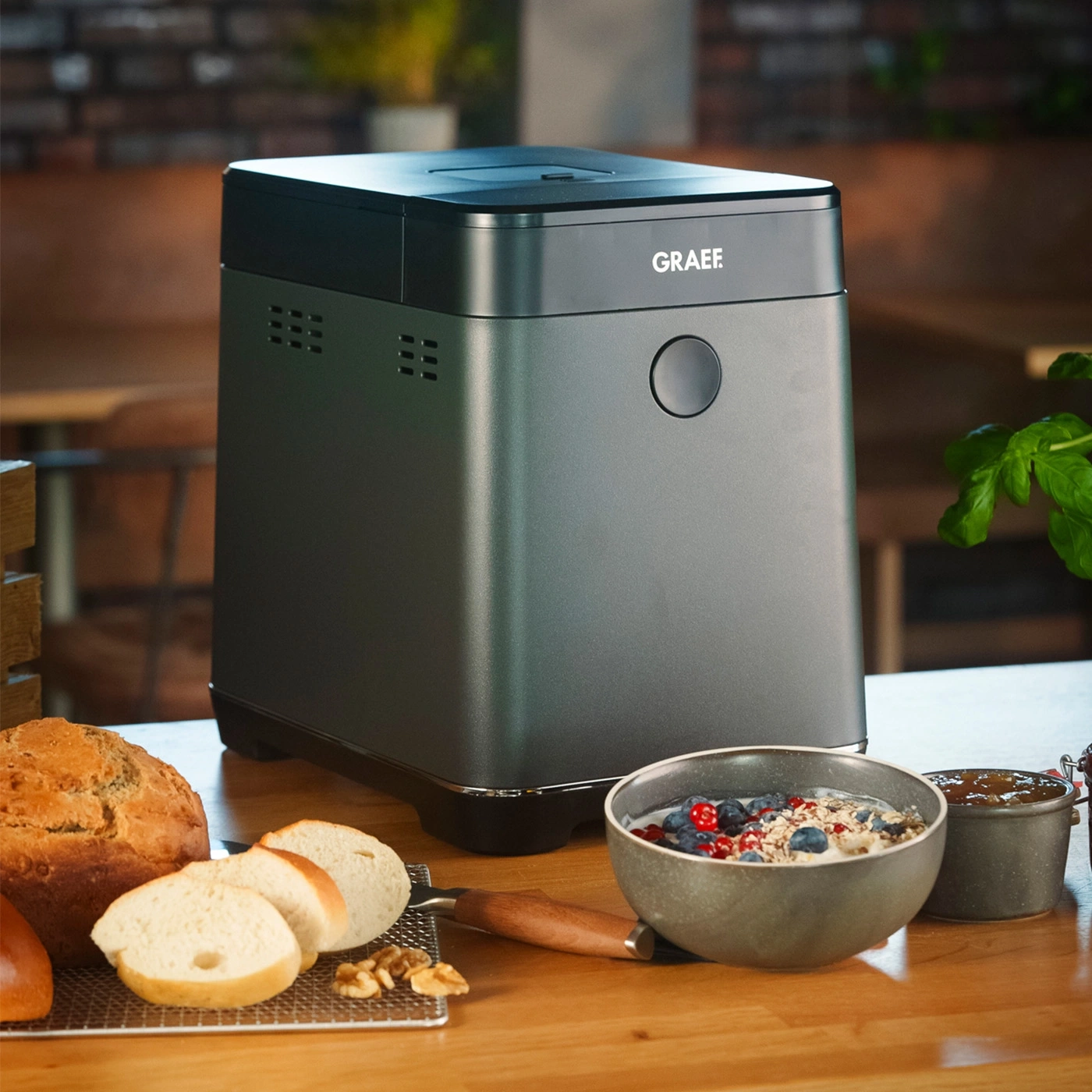 Brotbackautomat mit geschnittenem Brot und einer Müslischüssel im Vordergrund