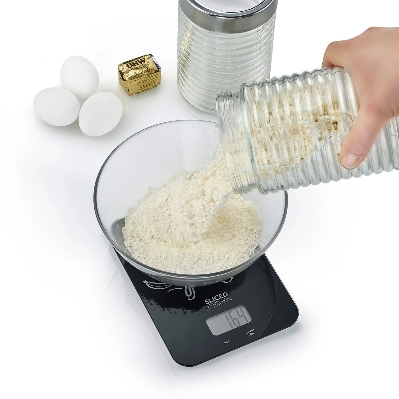 Mehl wird in eine Schüssel auf einer Waage gegossen, mit Eiern und Butter.