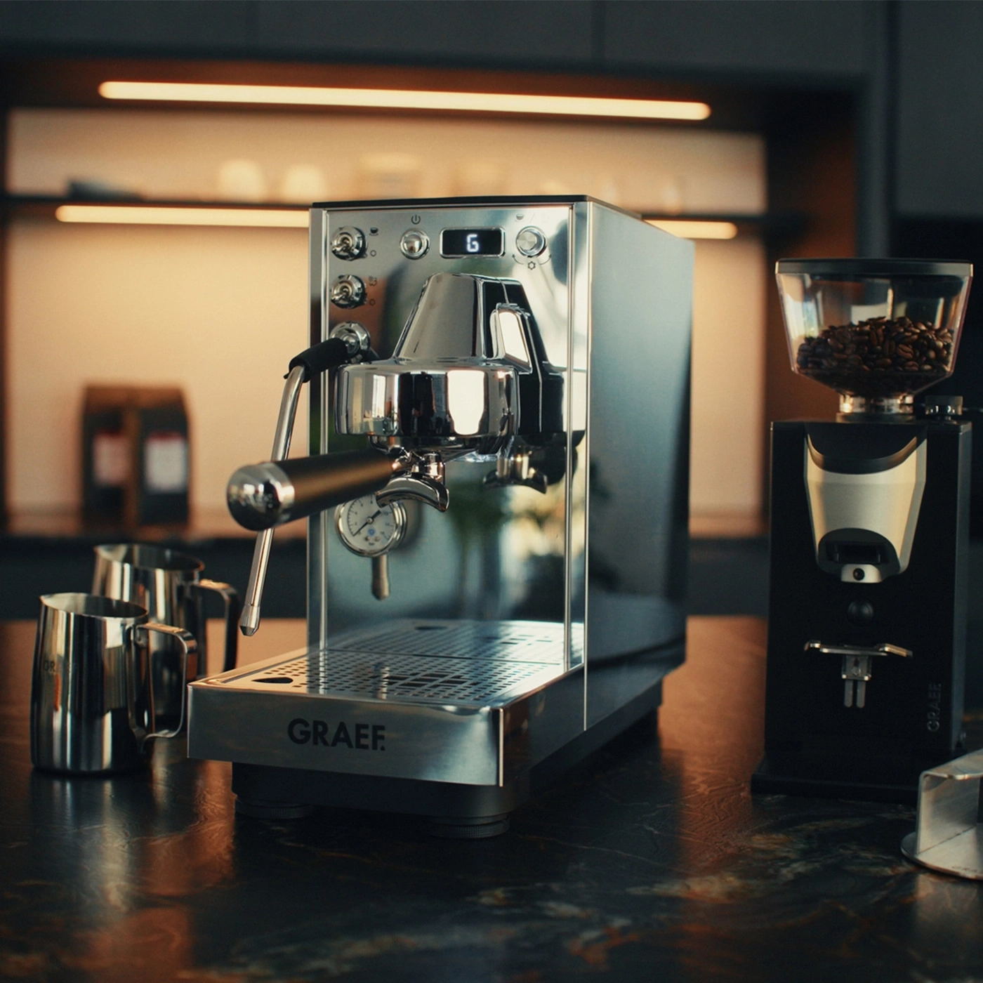 silberene GRAEF Siebträgermaschine, Milchkännchen und schwarze Kaffeemühle daneben