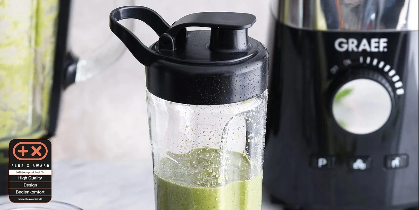 Mixer mit grünem Smoothie, schwarzem Deckel und Plus X Award Auszeichnung.