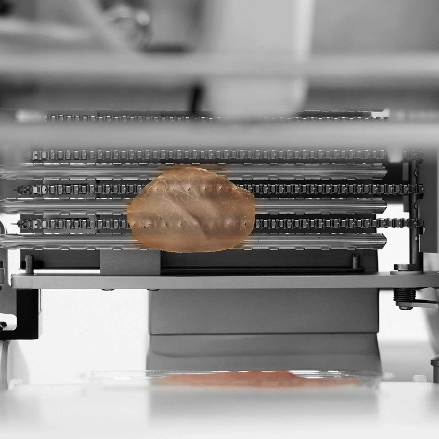 Maschine mit Fleischstück. Produktion, Verarbeitung, Lebensmittelindustrie, Technologie.