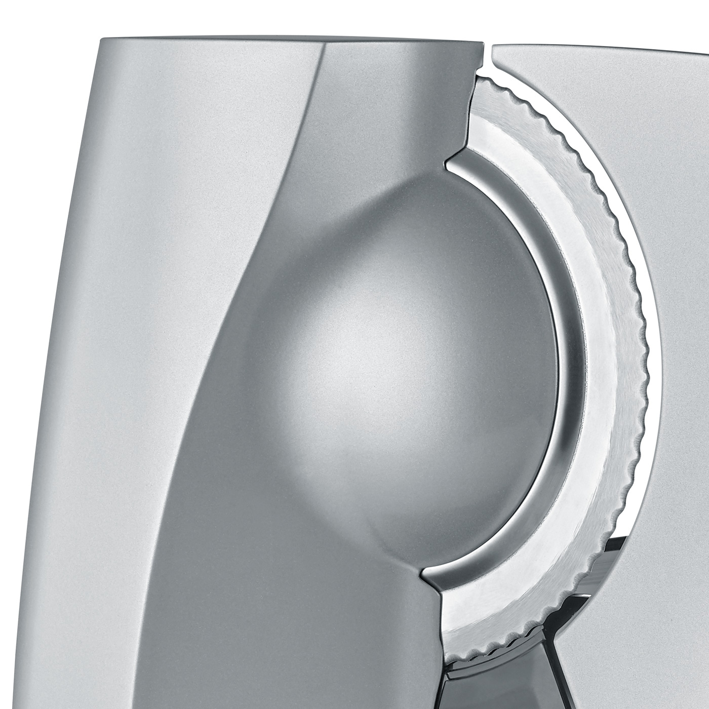 Nahaufnahme eines silbernen Fleischschneiders mit gezahnter Klinge und glatter Oberfläche