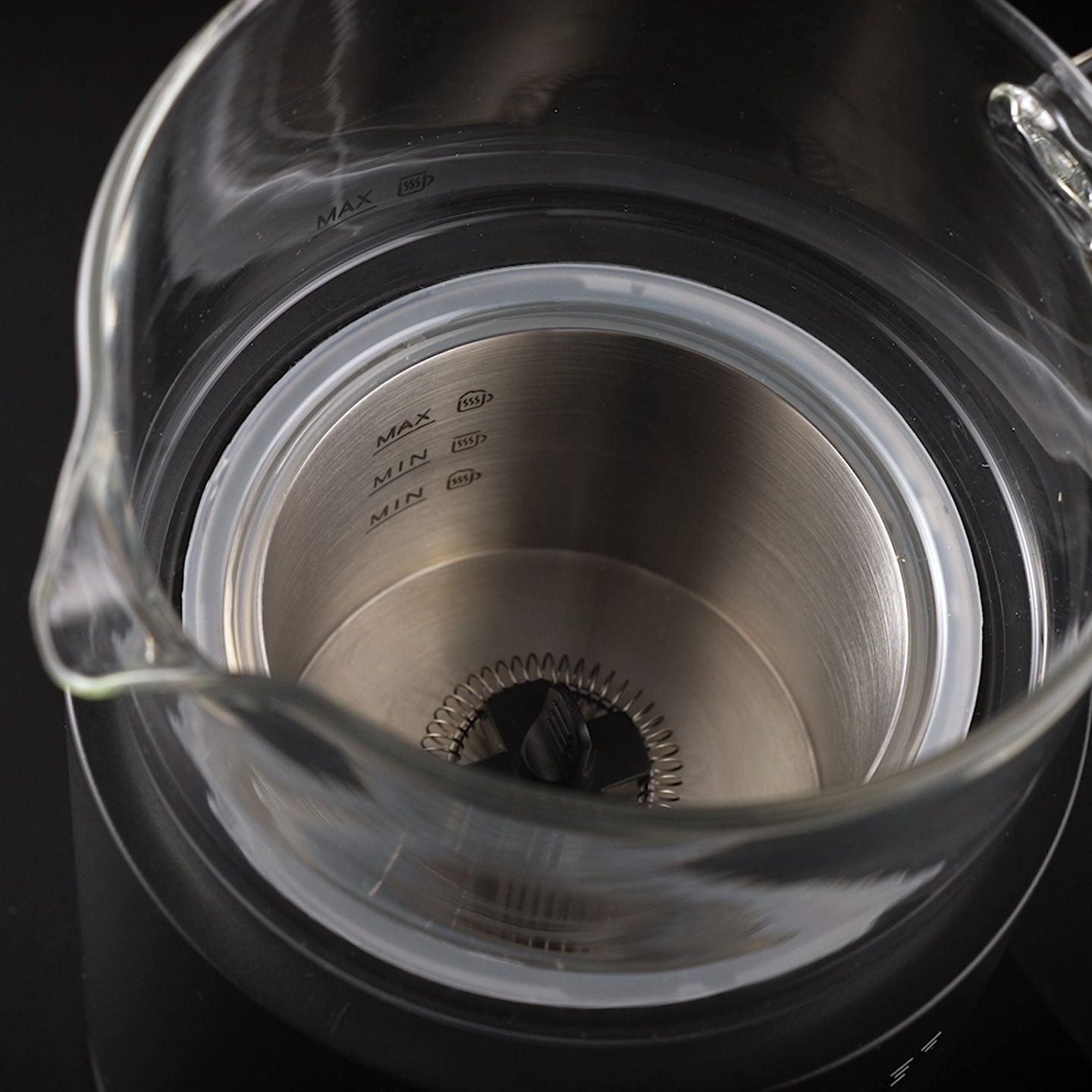 Nahaufnahme eines Glasbehälters mit Messmarkierungen für maximal und minimal.