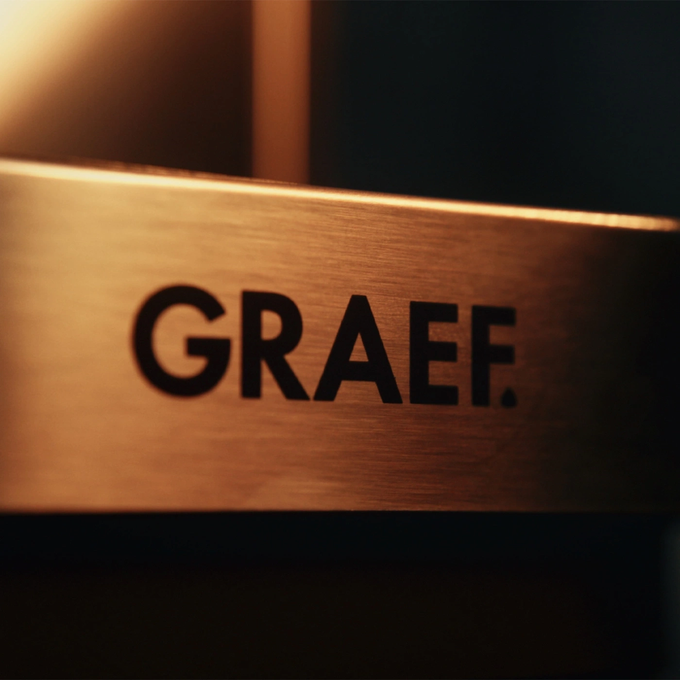 Das Logo GRAEF auf einem gebürsteten Metallband.