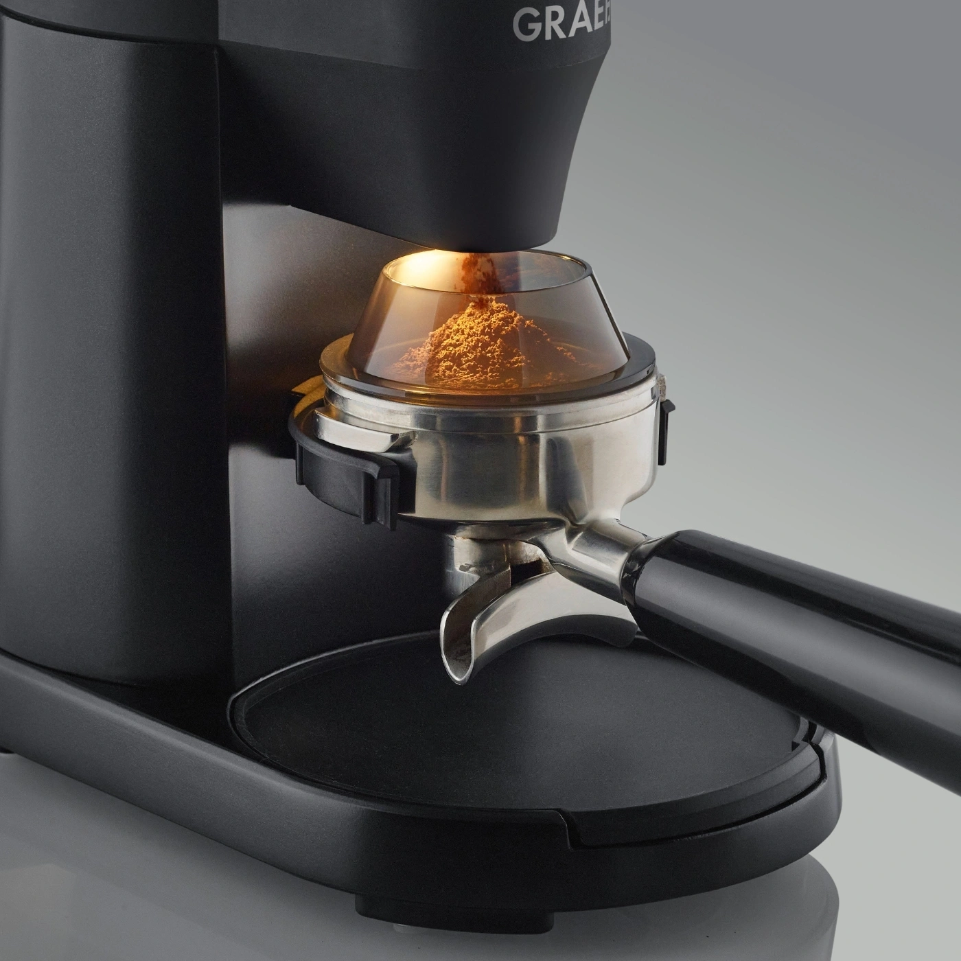 Kaffeemühle mit Kaffeepulver und Siebträger, Nahaufnahme, schwarz