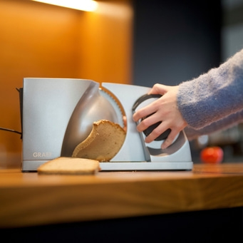 Bread being sliced with an electric bread slicer, close-up shot