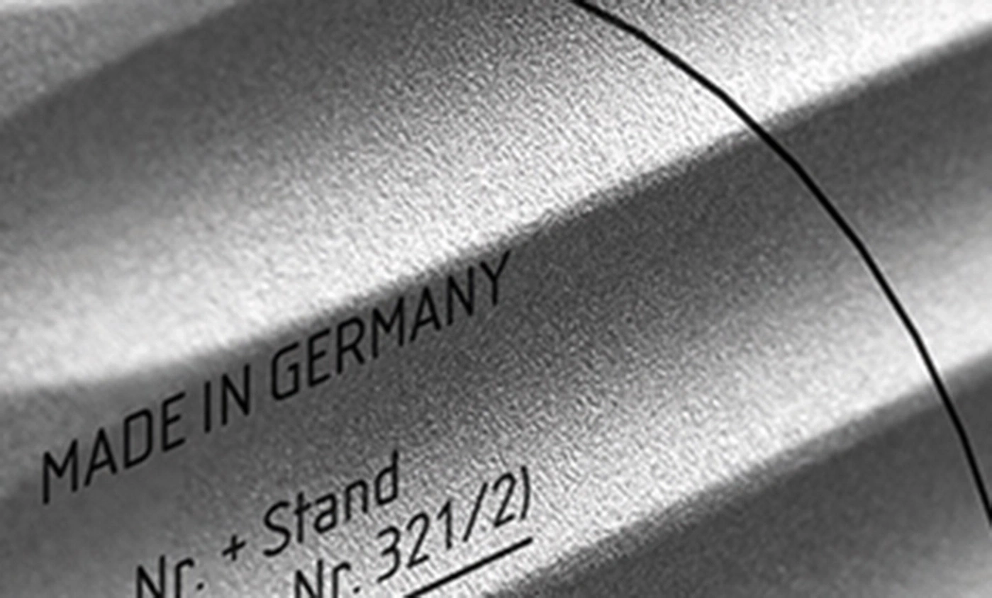 Made in Germany, Text auf Metalloberfläche, Nahaufnahme, schwarz-weiß, Produktkennzeichnung.
