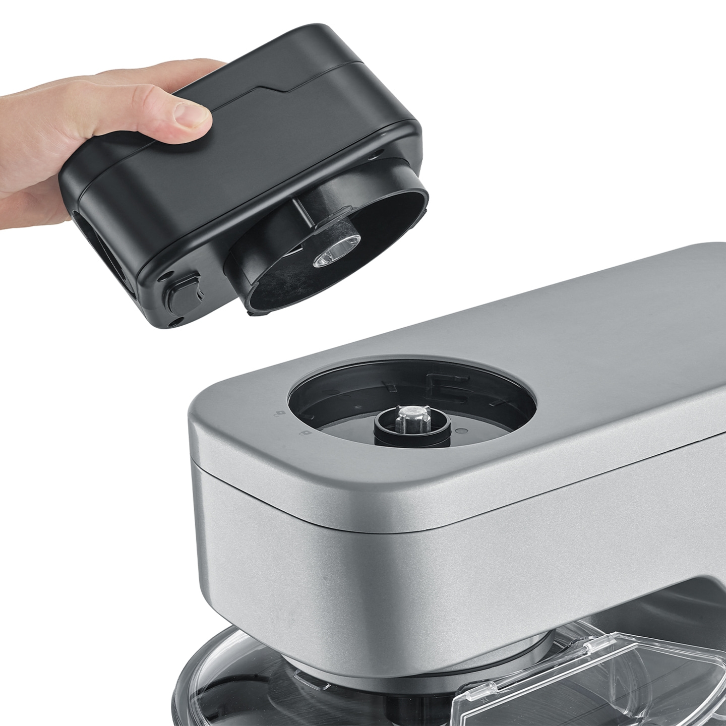 Hand holding black device over silver device to connect them together.