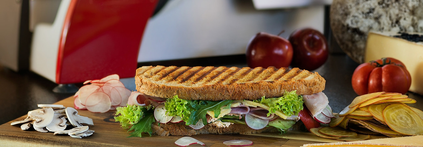 Délicieux sandwich avec légumes et fruits sur une planche de bois
