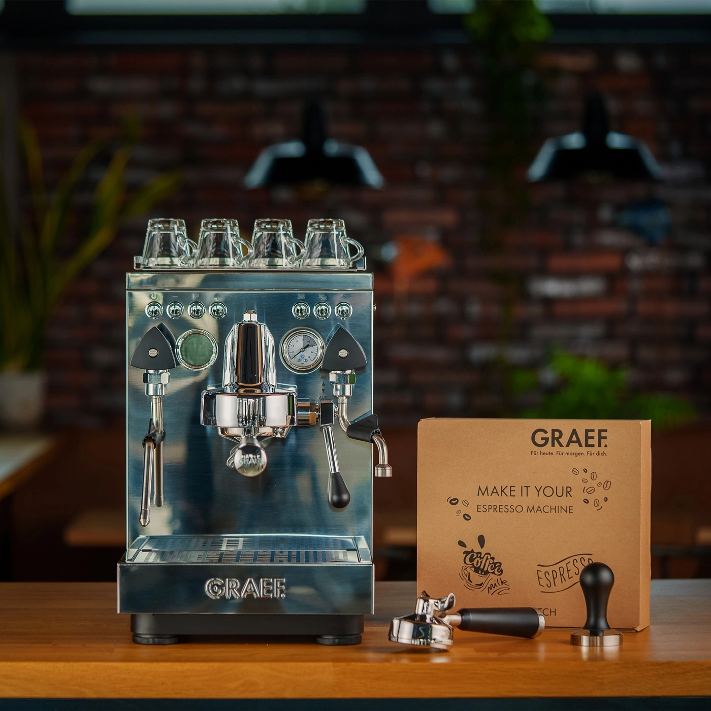 Espressomaschine mit Zubehör und Kaffeetassen.