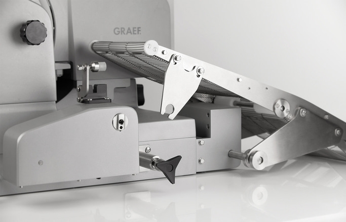 Nahaufnahme eines silbernen Graef-Schneiders mit Förderband und Einstellknopf.