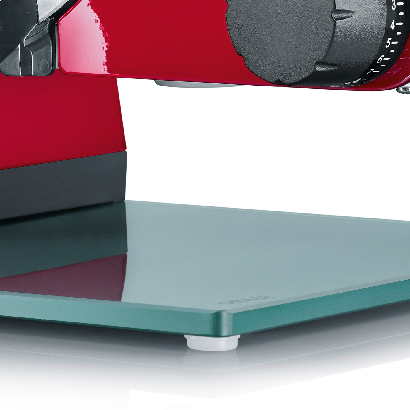 Nahaufnahme eines roten Fleischschneiders mit Glasplatte und Einstellknopf.