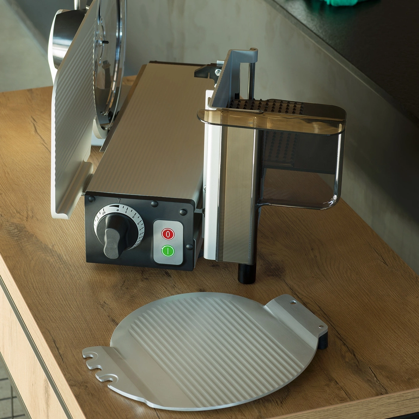 Fleischschneidemaschine auf Holztisch mit Zubehör und Knöpfen