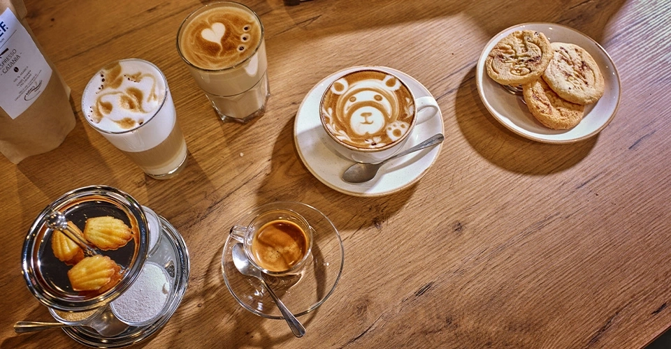 Kaffee, Gebäck und Holzoberfläche. Verschiedene Kaffeesorten und Kekse auf einem Holztisch.