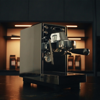 Siebträgermaschine, silber, dunkle Küche im Hintergrund