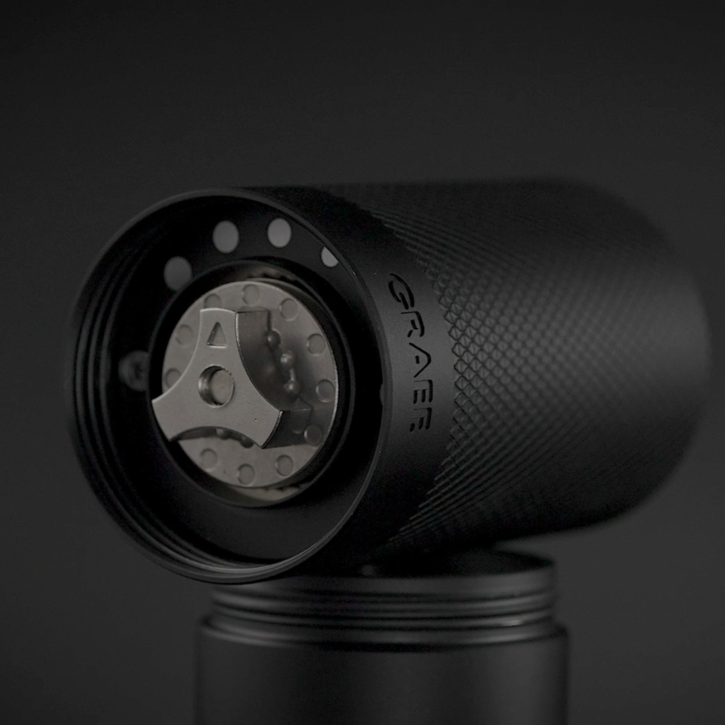 Schwarzer Kaffee-Mahlwerk mit "GRAEF"-Logo auf dunklem Hintergrund.