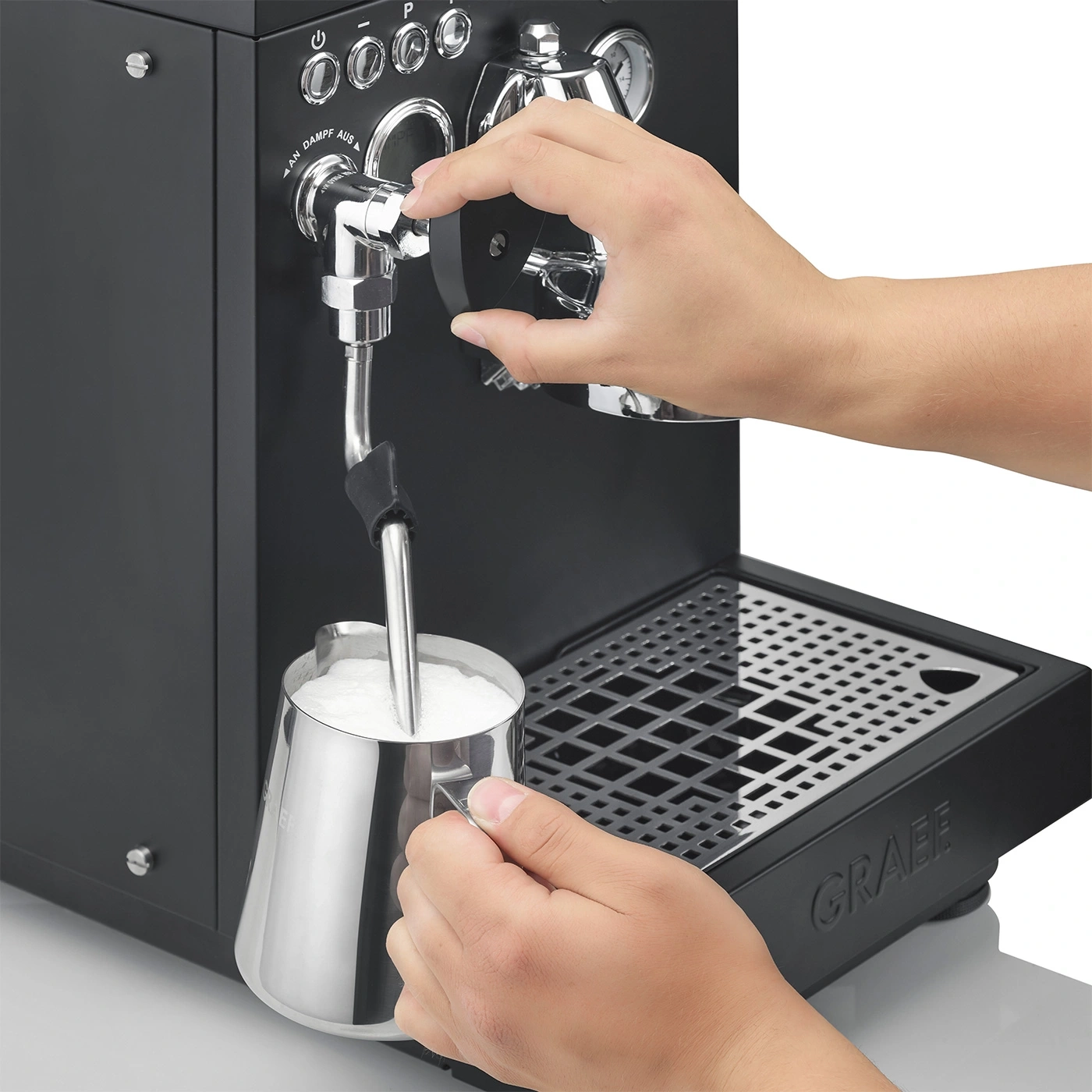 Person, die Milch mit einer Espressomaschine aufschäumt, um Kaffee zuzubereiten.