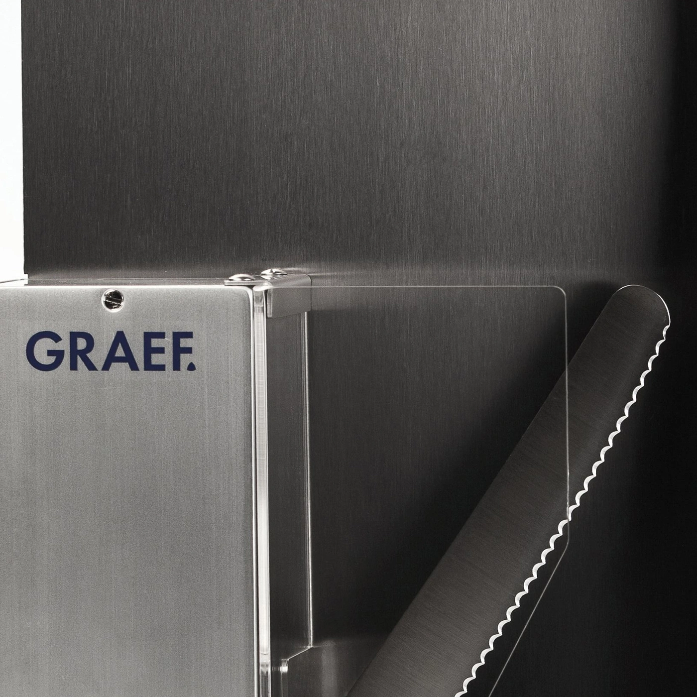 Graef-Logo auf Metalloberfläche mit gezahntem Messer und dunklem Hintergrund