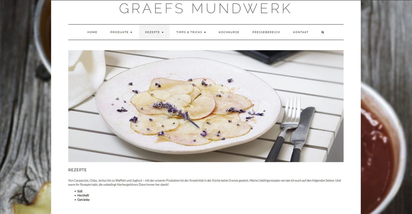 Webseite mit Rezepten, Essen auf einem Teller, Besteck, Text über Rezepte