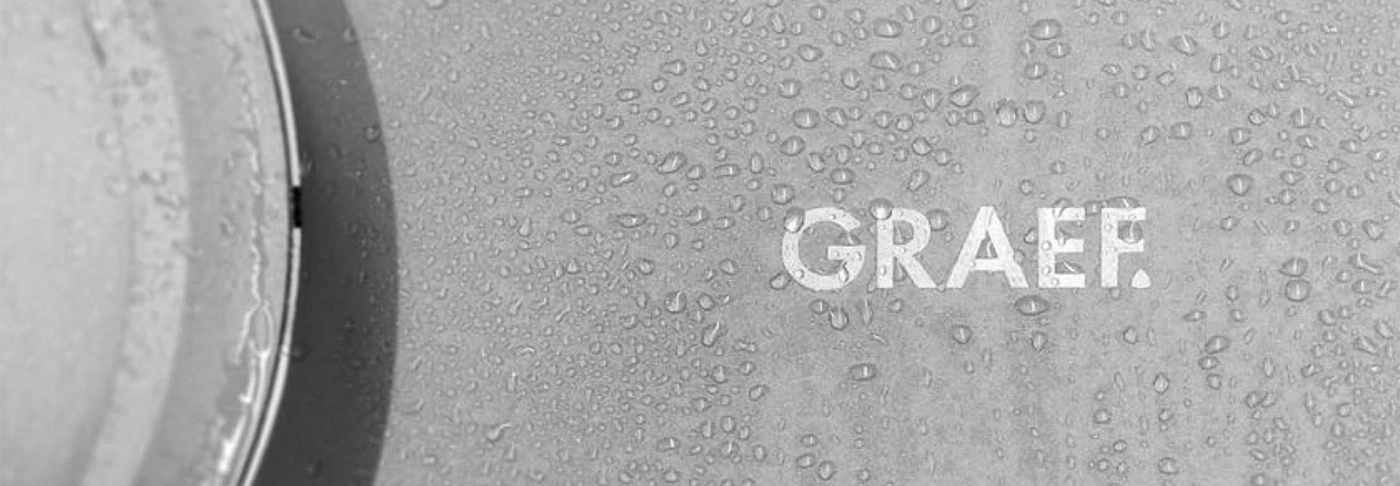 Graef-Logo auf einer nassen Oberfläche mit Wassertropfen, grau