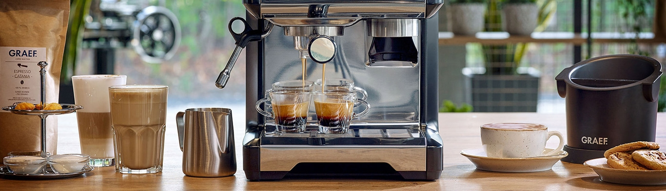 Macchina da caffè con espresso, tazze, latte, biscotti e chicchi di caffè