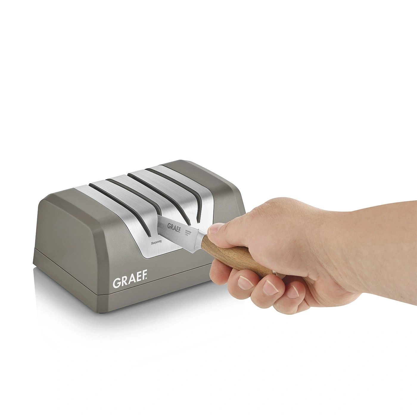 Messer schärfen mit GRAEF-Schärfer. Grauer Schärfer und Messer in der Hand.