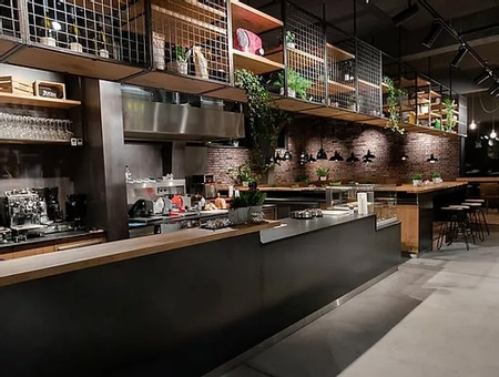 Interno di un bar con bancone, scaffali e piante, design moderno