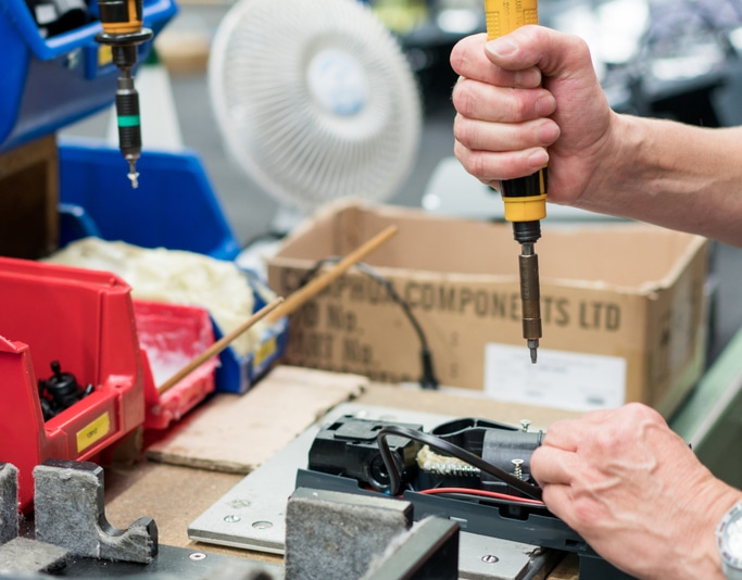 Blick in die Produktion eines Allesschneiders, Aufnahme der Hände mit Werkzeug