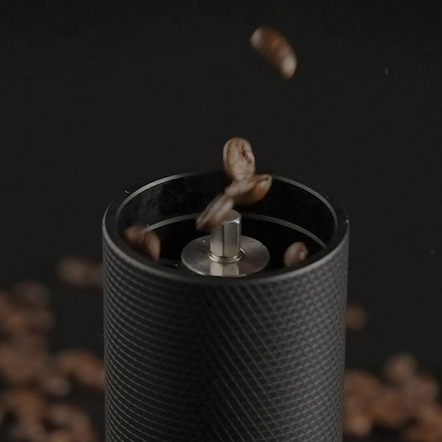 Kaffeebohnen fallen in eine Kaffeemühle, Nahaufnahme.